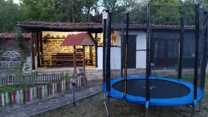 a playground with a trampoline in front of a house at Къща за гости Роза in Elena
