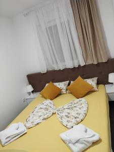 a yellow bed with a bow tie on it at Apartment with pool in Veliko Gradište +64 photos