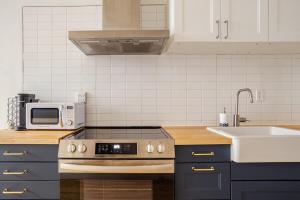 a kitchen with a stove top oven next to a sink at Haute mer in Quebec City