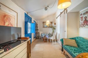 ein Wohnzimmer mit Sofa und Tisch in der Unterkunft Authentic fisher house in Pedregalejo - TCM in Málaga + 7 Fotos