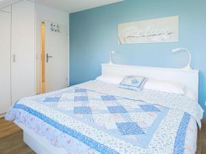 a blue bedroom with a bed with a quilt on it at Kaiserhof 18 Wohnung 16 in Kellenhusen