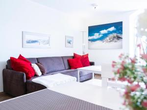 a living room with a couch and red pillows at Kaiserhof 18 Wohnung 16 in Kellenhusen