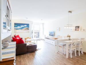 a white living room with a table and a couch at Kaiserhof 18 Wohnung 16 in Kellenhusen
