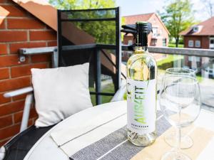 a bottle of wine sitting on a table with glasses at Kaiserhof 18 Wohnung 16 in Kellenhusen +30 photos