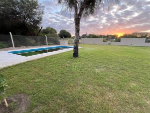 a tree in a yard with a swimming pool at Finca en BARRIO CERRADO EL CALDEN in Santiago del Estero