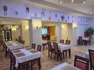 a restaurant with tables and chairs in a room at Villa Murano in Sajzy