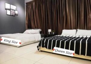 two beds sitting next to each other in a bedroom at Puchong Skypod 9pax Near Sunway in Puchong +37 photos