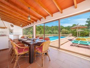 a dining room with a table and chairs and a pool at Holiday Home Lisboa by Interhome in Cala Murada
