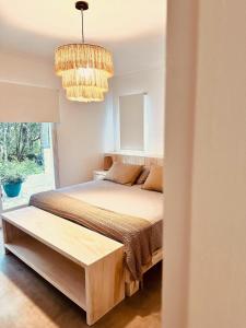 una camera da letto con un letto e un lampadario di CASA TOSSA en Solanas Vacation Club a Punta del Este