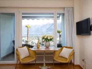 a living room with a table and chairs and a window at Apartment Double Room Classic-5 by Interhome in Ascona