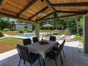 Un patio con mesa y sillas y una piscina. en Holiday Home Nino by Interhome, en Kršan