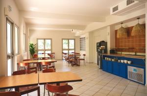 a restaurant with tables and chairs and a kitchen at Hôtel Les Rives Bleues in La Grande Motte