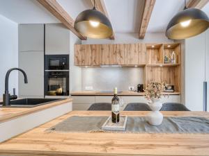 a kitchen with a wooden table with a bottle of wine at Holiday Home Domagoj by Interhome in Malinska