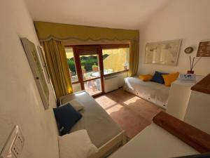 a small living room with a couch and a window at Appartamento tra Verde e Mare by Holiday World in Punta Ala