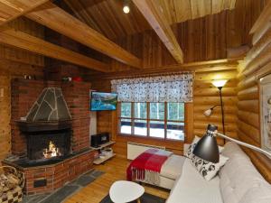 ein Wohnzimmer mit Kamin in einer Blockhütte in der Unterkunft Holiday Home Varilan lomamajat nr1 by Interhome in Ruka + 12 Fotos