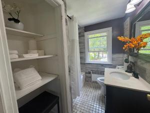 a bathroom with a sink and a toilet and a window at Cozy Home in New Britain