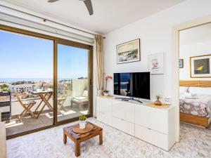 a living room with a tv and a large window at Apartment O-House by Interhome in Torremolinos