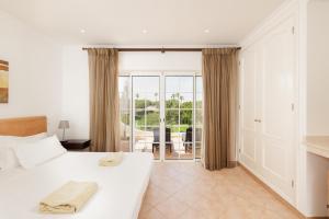 a bedroom with a large bed and a balcony at Vale Do Lobo Resort in Vale do Lobo