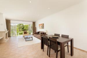 a dining room and living room with a table and chairs at Vale Do Lobo Resort in Vale do Lobo