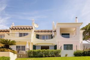 a large white house with a clock on top of it at Vale Do Lobo Resort in Vale do Lobo