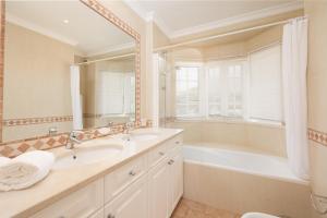 a bathroom with a tub and a sink and a bath tub at Vale Do Lobo Resort in Vale do Lobo