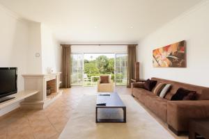 a living room with a couch and a tv at Vale Do Lobo Resort in Vale do Lobo