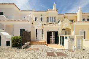 a large white house with a gate at Vale Do Lobo Resort in Vale do Lobo