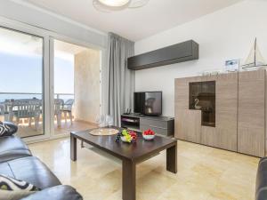 a living room with a coffee table and a television at Apartment Blanes Playa by Interhome in Blanes