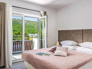 a bedroom with a large bed and a balcony at Holiday Home Manea by Interhome in Tribalj