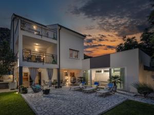 a large white house with a patio at night at Holiday Home Manea by Interhome in Tribalj