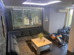 瓦尔纳Luxury Seaside Villa with Jacuzzi & Garden - Varna的客厅里有一张沙发和一张桌子。