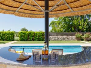 une table avec une bouteille de vin et des verres sous un parasol dans l'établissement Holiday Home Villa Tanja by Interhome, à Dračan
