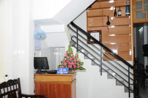 a room with a staircase with a television and flowers at Bien Khoi Mini Hotel in Hue