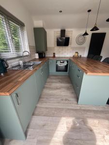 a kitchen with blue cabinets and wooden counter tops at Sunset Retreat in Three Legged Cross