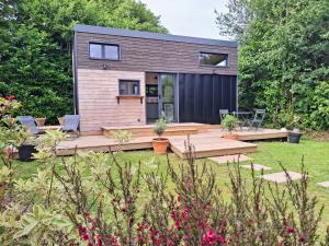 a tiny house in a garden with a deck at My Tiny House proche mer in Clohars-Fouesnant