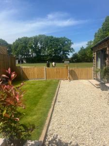 a garden with a fence and a horse behind it at Sunset Retreat in Three Legged Cross