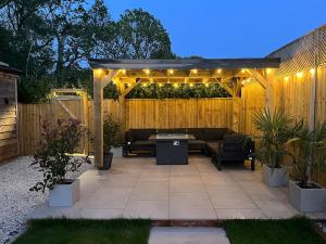 a patio with a couch under a pergola with lights at Sunset Retreat in Three Legged Cross