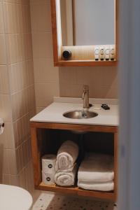 a bathroom with a sink and a bunch of towels at Man Met Bril Koffie Hotel in Rotterdam +45 photos