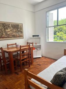 a dining room with a table and chairs and a window at Apartamento Historico Beira Mar - Na avenida da Praia in Santos