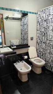 a bathroom with a toilet and a sink and a mirror at Santiago 700 in San Miguel de Tucumán