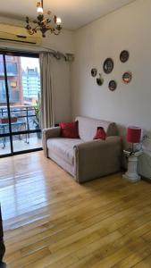 a living room with a couch on a wooden floor at Santiago 700 in San Miguel de Tucumán