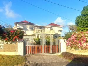 une maison blanche avec une porte en face dans l'établissement Castlevue B&B, à Montego Bay