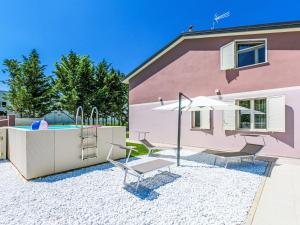 チェチナにあるHoliday Home Borgo il Vallin delle Conche-2 by Interhomeの遊び場と傘のあるピンクの家