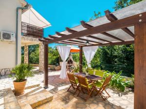 a patio with a table and chairs under a wooden pergola at Holiday Home Nira by Interhome in Rabac +49 photos