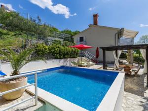 a swimming pool in front of a house at Holiday Home Nira by Interhome in Rabac