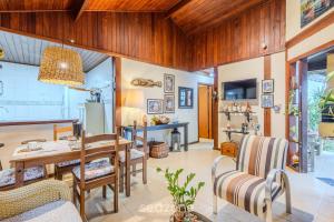 a dining room with a wooden table and chairs at Casa charmosa c/ churrasq. ao lado do Mar MON0099 in Itajubá