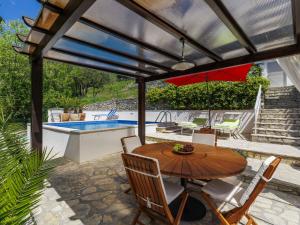 a patio with a table and chairs and a pool at Holiday Home Nira by Interhome in Rabac