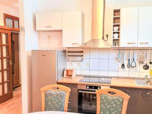 a kitchen with a refrigerator and two chairs in it at Apartment Marija-2 by Interhome in Pridraga