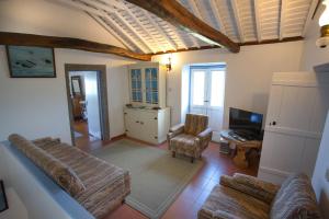 a living room with a couch and a television at GuestReady - Rustic haven in northeast in Nordeste