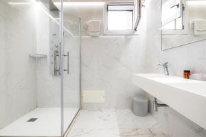 Un baño blanco con ducha y lavabo. en Masseria Tenuta Quintino, en Torre Lapillo 27 fotos más